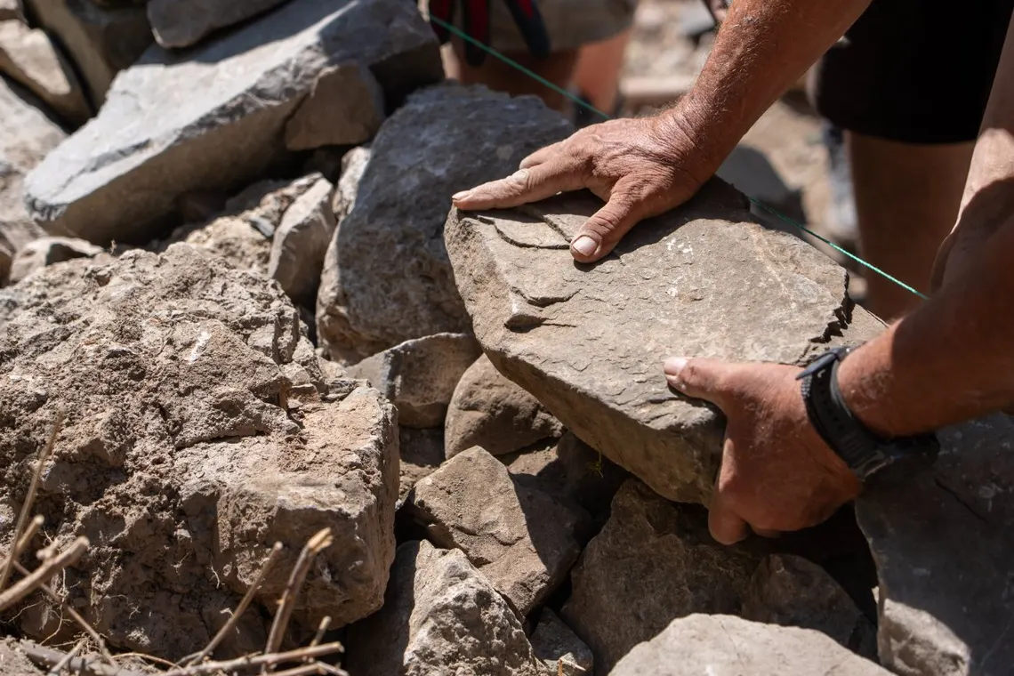Hands fitting a stone into the wall